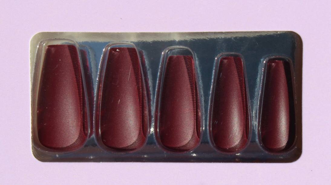 Set of burgundy press-on nails in packaging