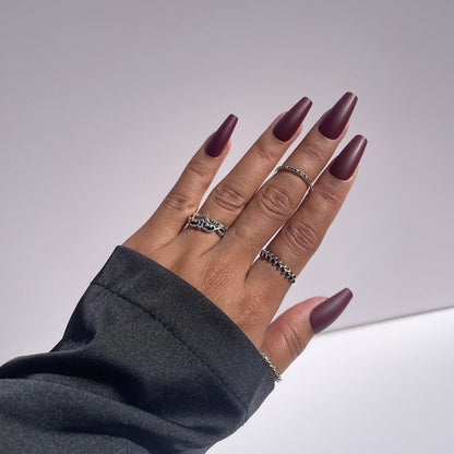 Hand showing burgundy coffin-shaped press-on nails