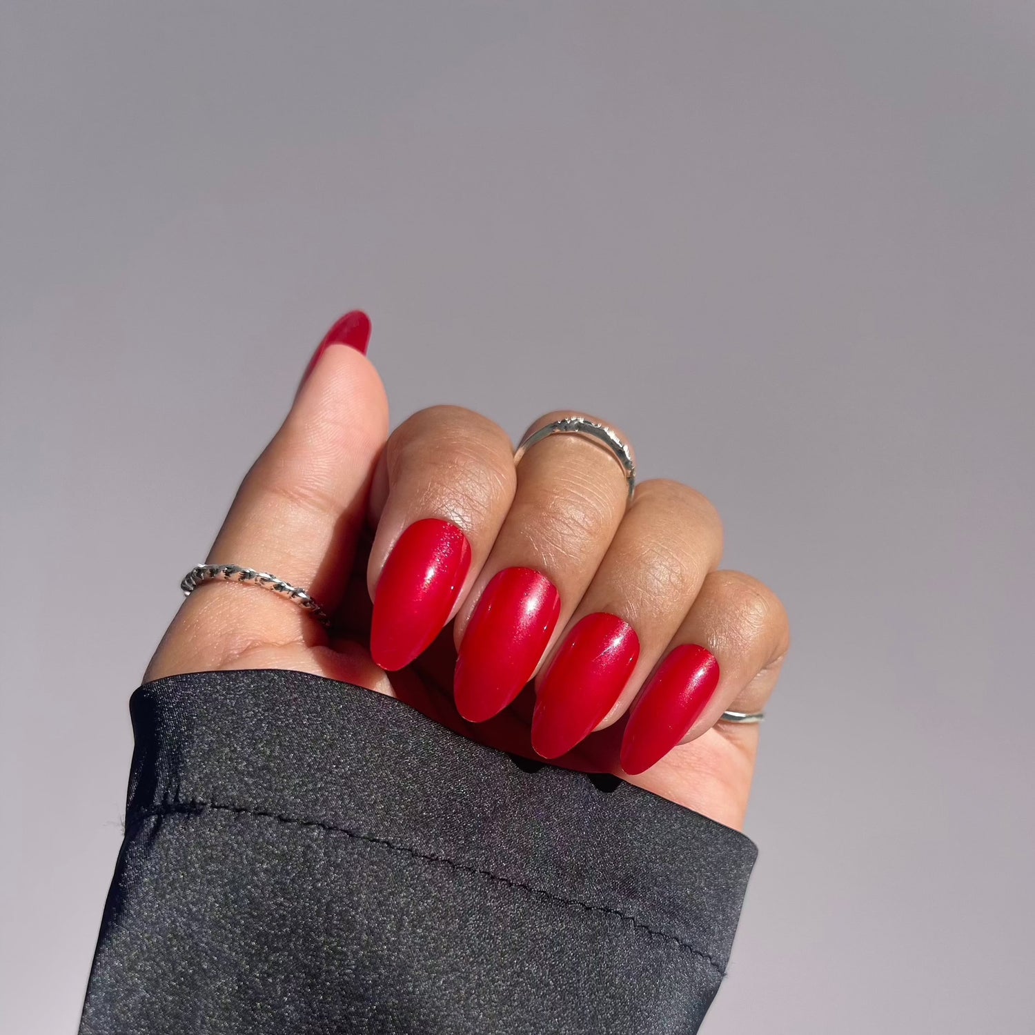 Hand with classic red almond-shaped press-on nails