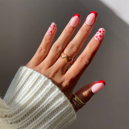 Hand wearing Esme press-on nails with red French tips