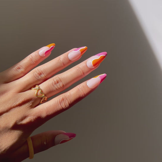 Almond-shaped DANA nails featuring bold orange and coral colors.