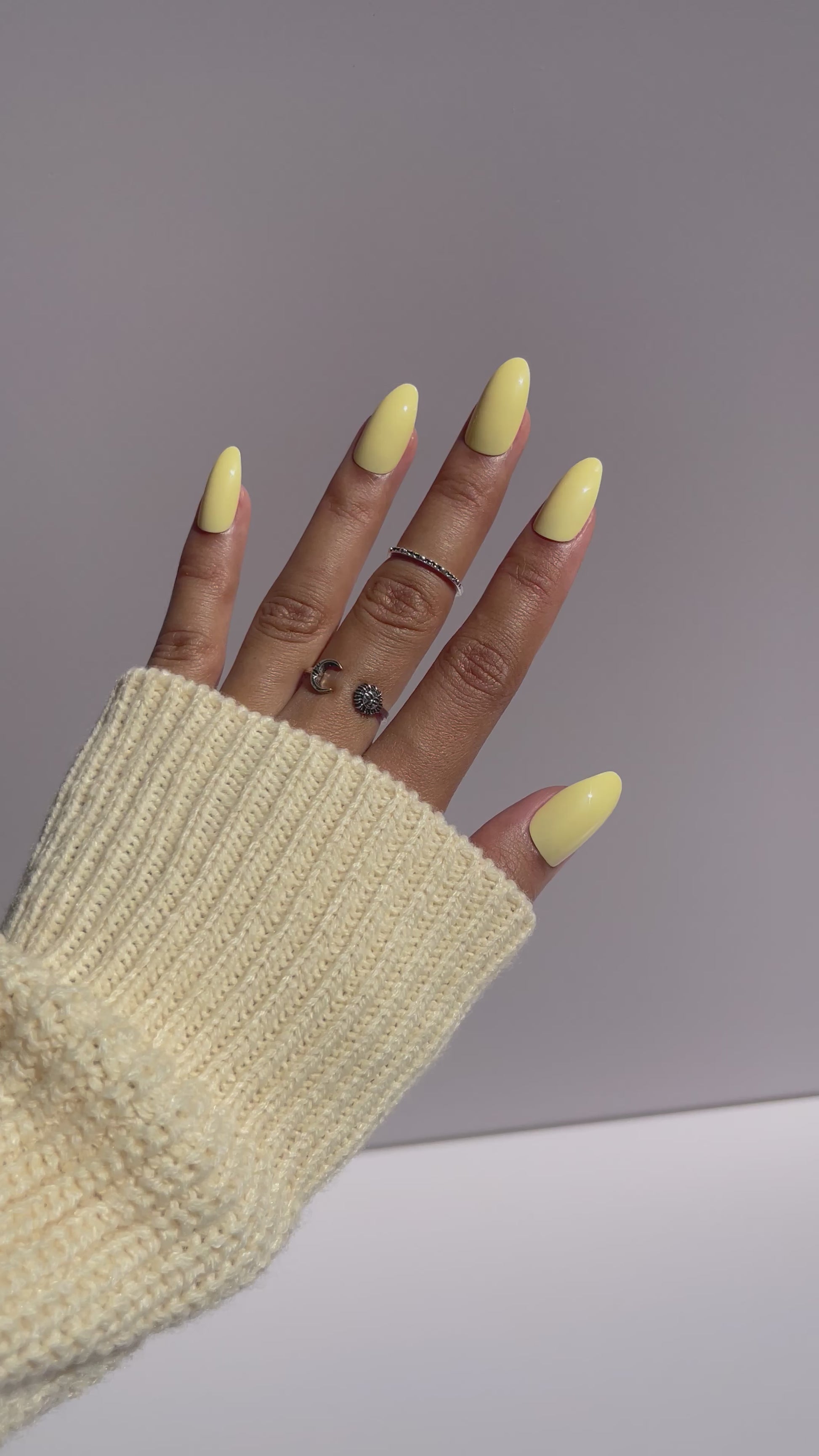 Trendy pastel yellow nails with cream sweater