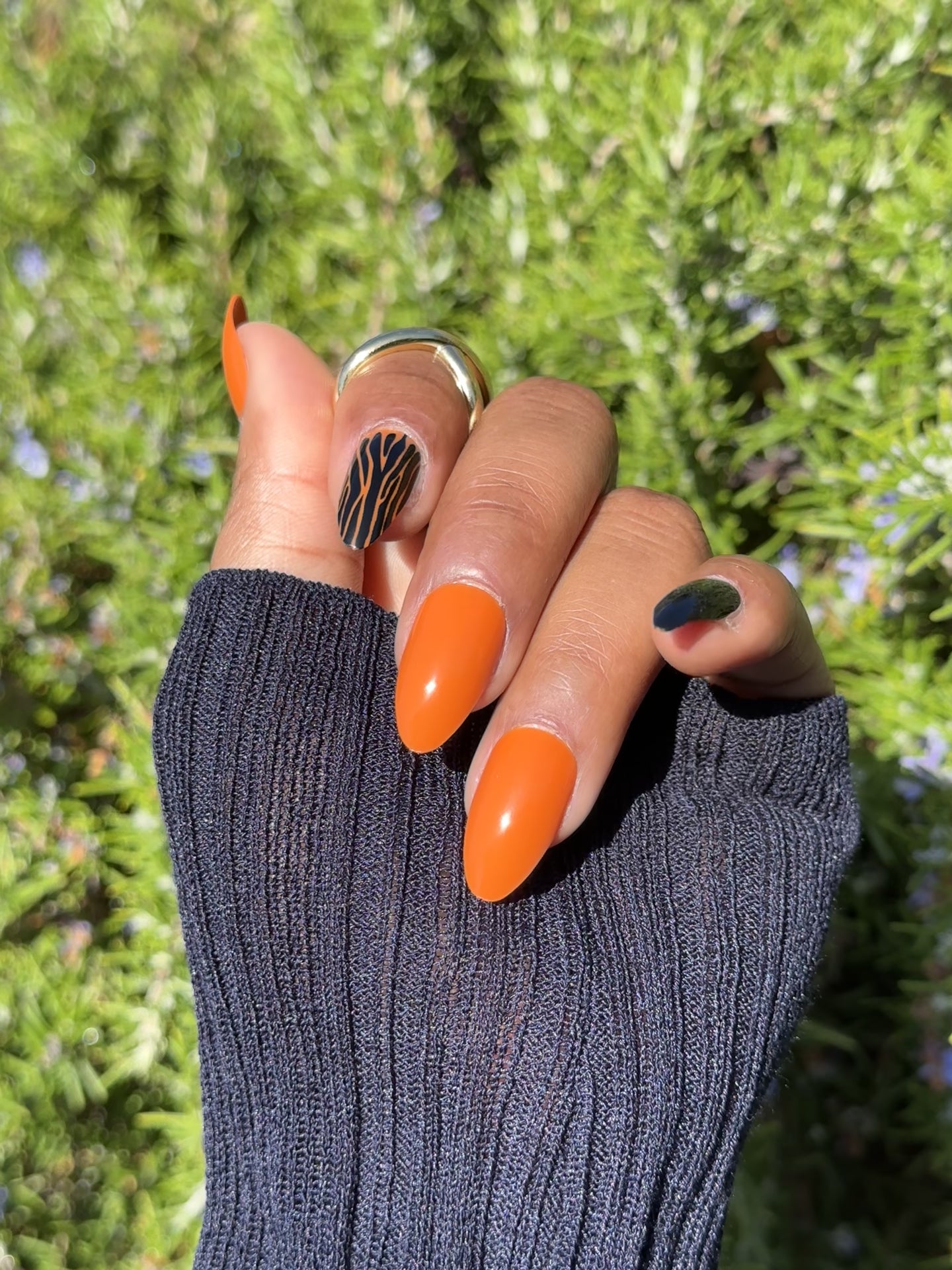 Close-up of Halloween press-on nails in orange and black with zebra design