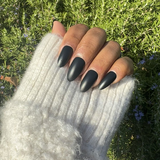 Close-up of black almond press-on nails outdoors