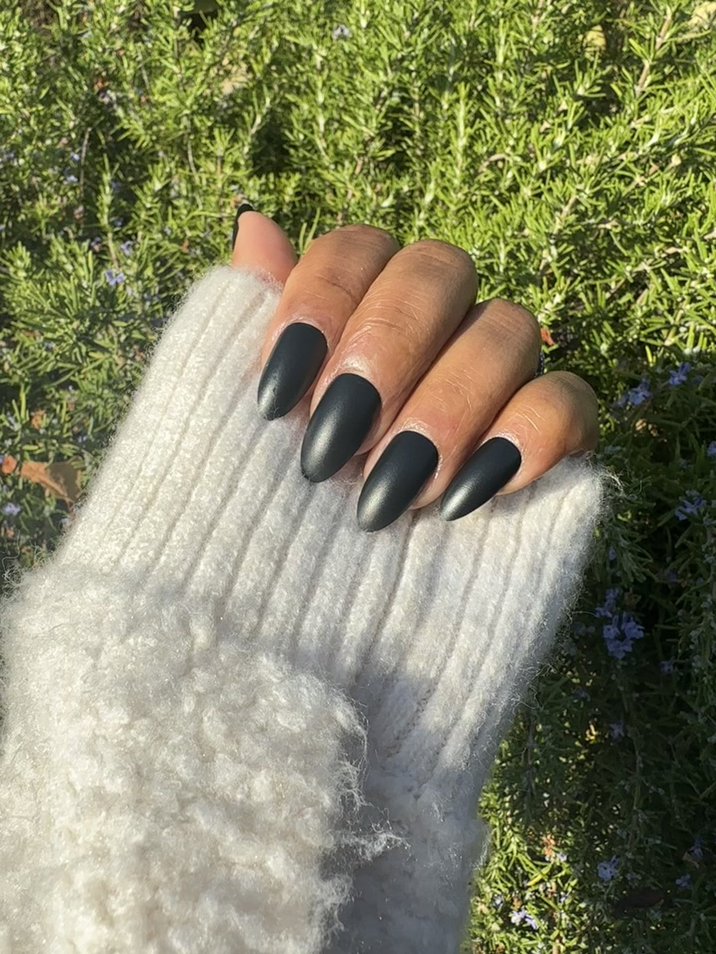 Close-up of black almond press-on nails outdoors